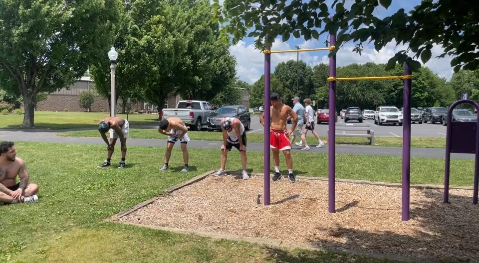 Rome Rizzo training with a group at outdoor pull-up bars