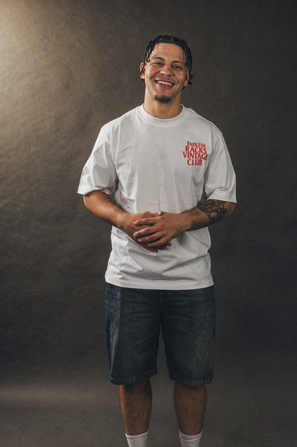 Front-view studio modeling shot of Rome Rizzo in a white T-shirt and denim shorts for Endless Racks Vintage Club