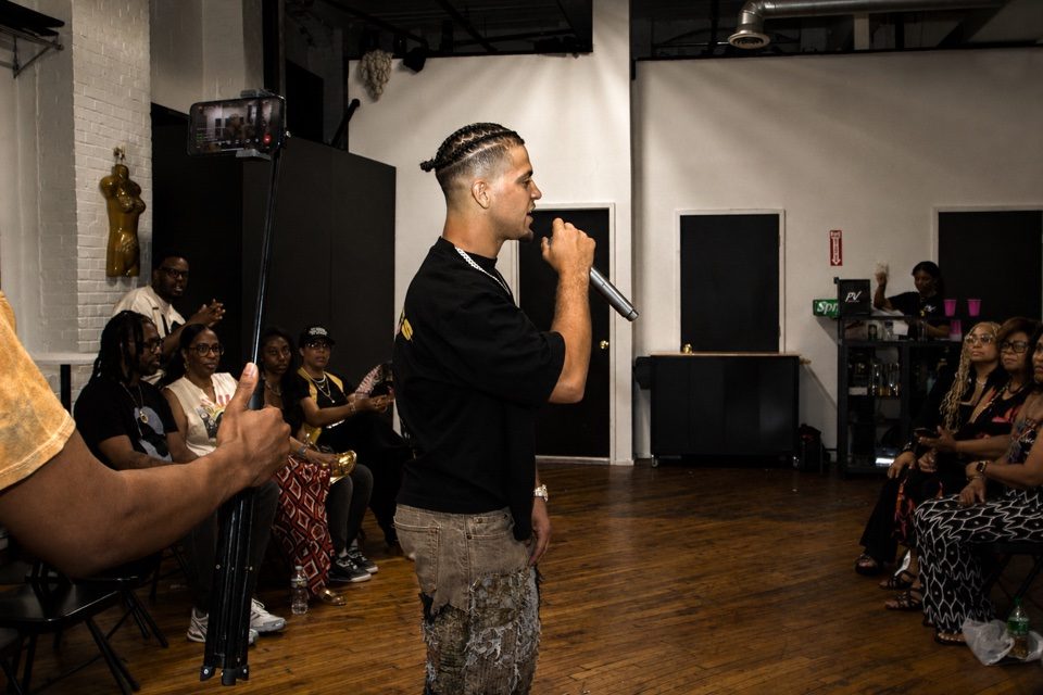 Side profile of Rome Rizzo performing with a microphone