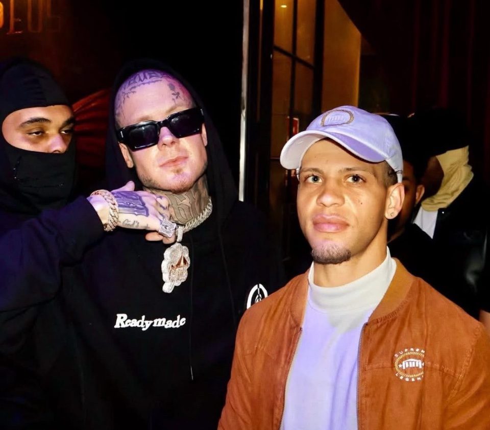 Rome Rizzo posing with a tattooed artist backstage